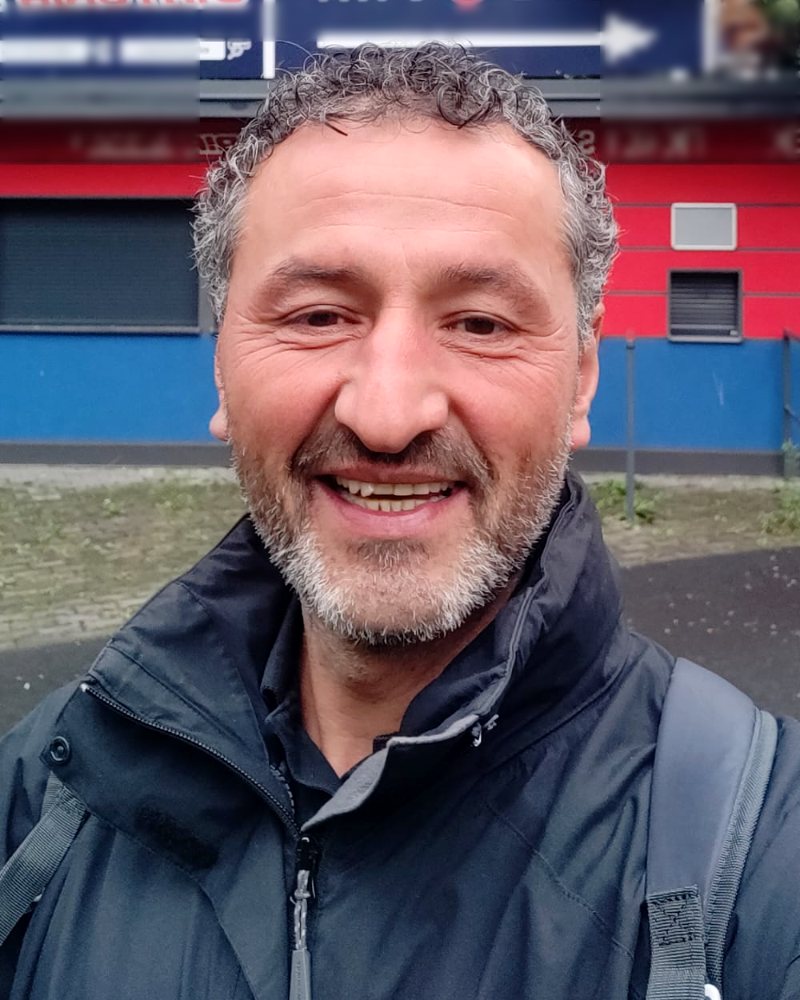 Meté Akinci op de bouwplaats, met helm en veiligheidshesje