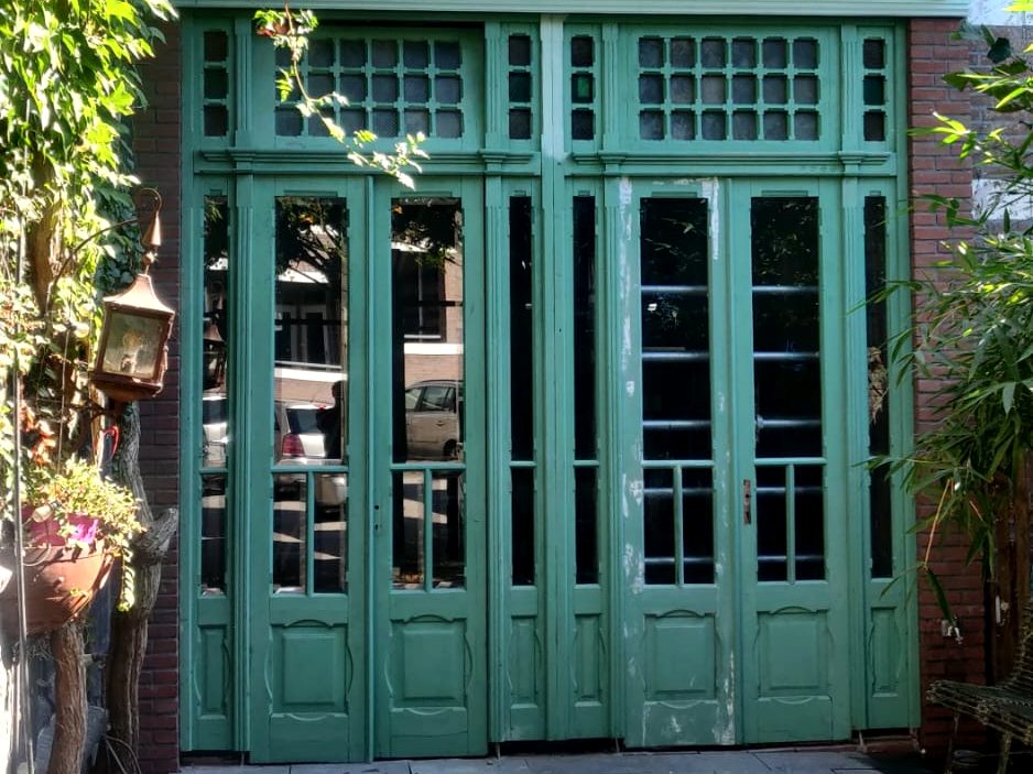 Nieuwe groene houten pui met glas-in-loodbovenlichten aan de tuinkant